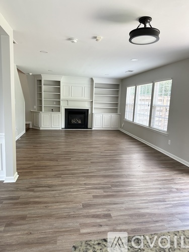A living room with wood flooring and a fireplace.