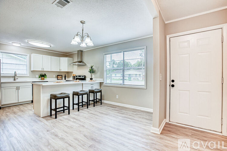 A kitchen with white cabinets and a bar area.