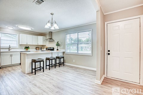 A kitchen with white cabinets and a bar area.