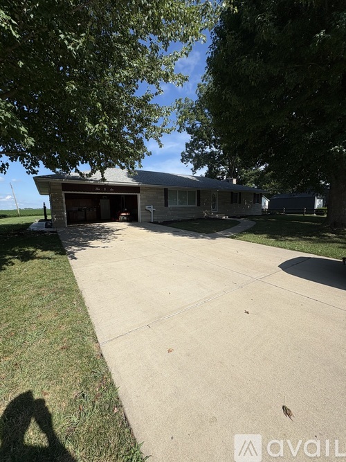 A house with a driveway and a tree in front.