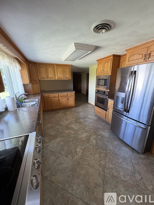 A kitchen with wooden cabinets and a tile floor.