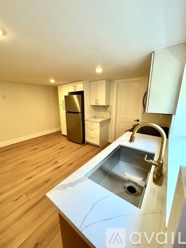 A kitchen with a sink and a refrigerator.
