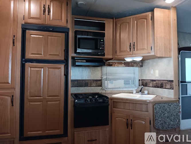 A kitchen with wooden cabinets and black appliances.