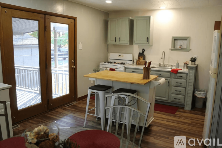 A kitchen with a table and chairs in front of a window.