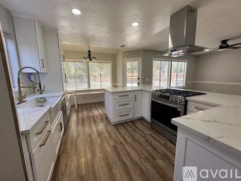 A kitchen with white cabinets and a wooden floor.