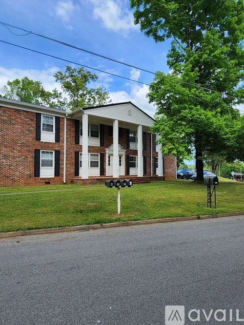 A house with a white porch and black shutters is for sale.