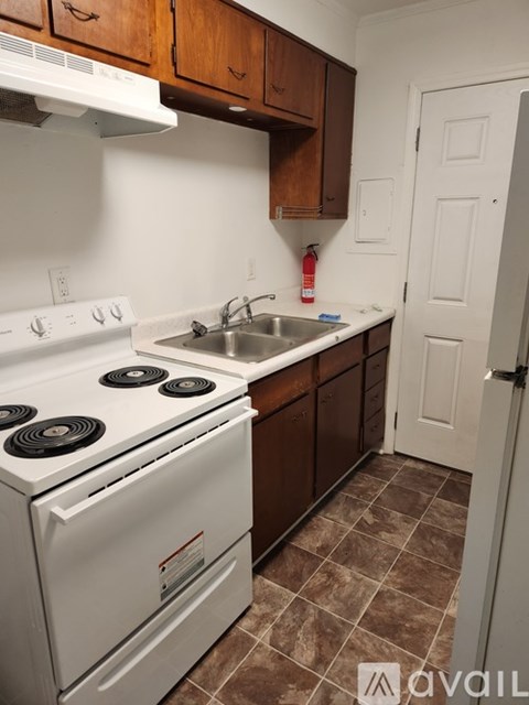 A kitchen with white appliances and brown cabinets.