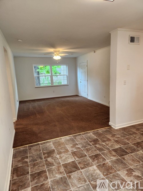 A room with brown tiled flooring and a window.