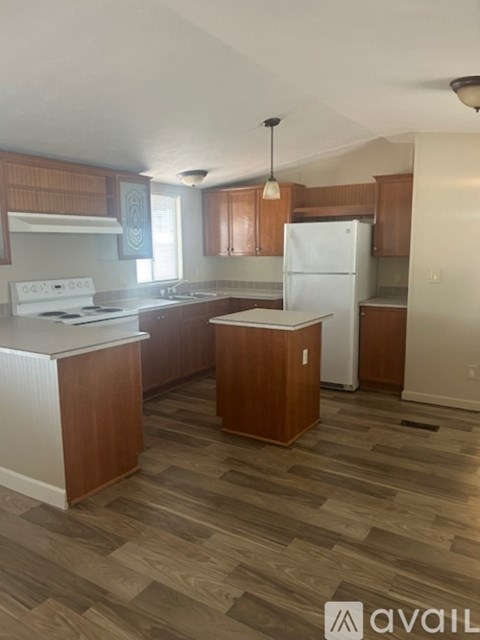 A kitchen with wooden cabinets and a white fridge.