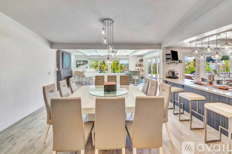 A modern dining room with a glass table and chairs.