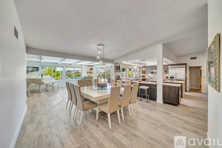 A spacious dining area with a long table and chairs.