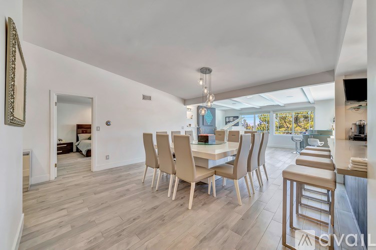 A dining room with a long table and chairs.