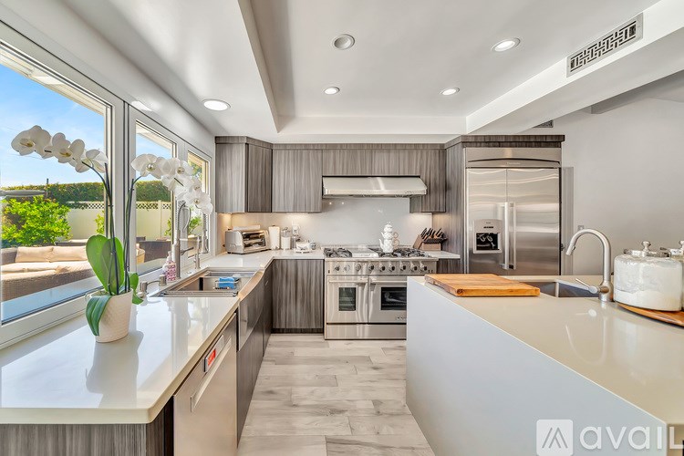 A modern kitchen with a large island and stainless steel appliances.