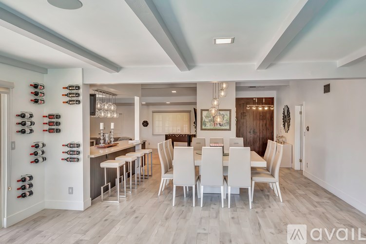 A modern kitchen with a dining area and a wine rack.