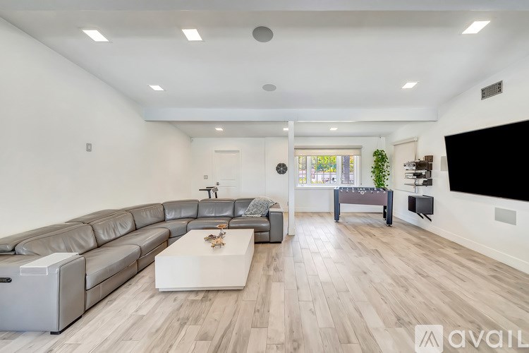 A modern living room with a grey sofa and a white coffee table.