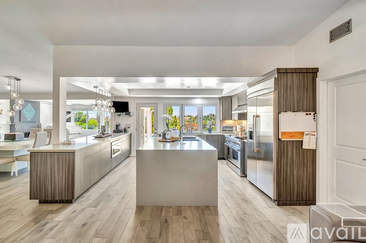 A modern kitchen with wooden floors and white walls.