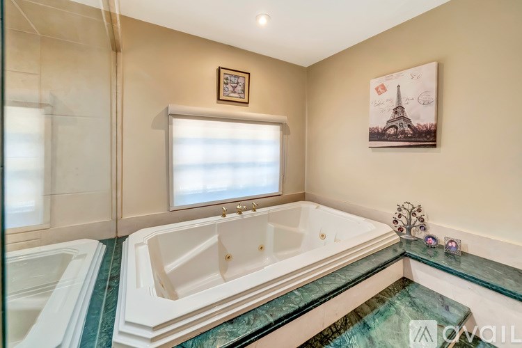 A bathroom with a large tub and a small sink.