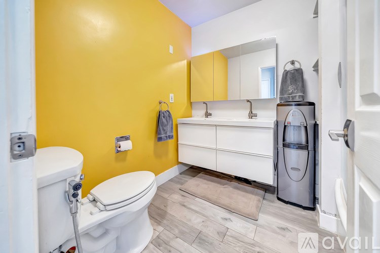 A bathroom with yellow walls and a white toilet.