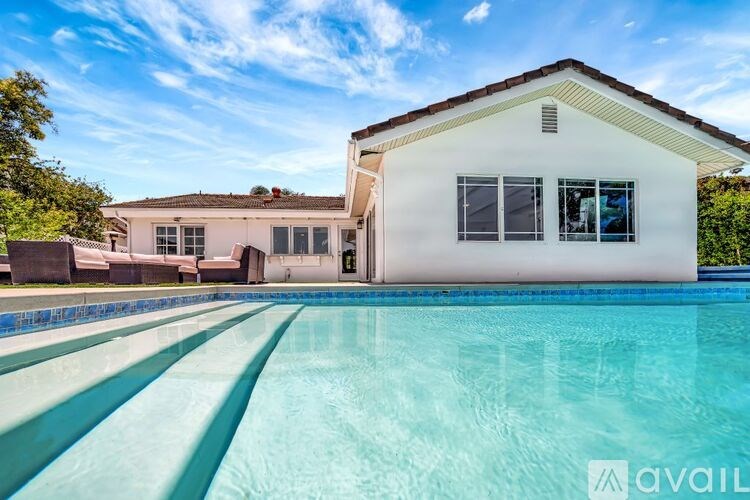 A house with a pool in front of it is for sale.