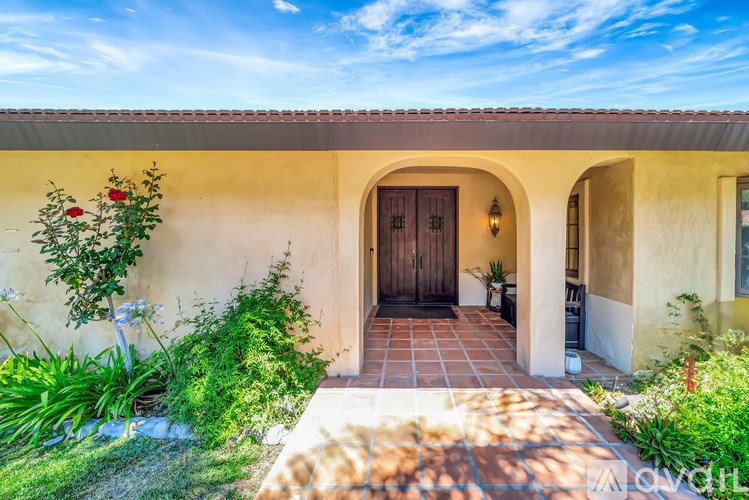 A house with a brown door and a small garden in front.