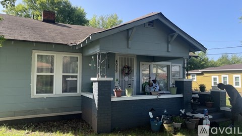 A house with a grey exterior and a person standing on the porch.