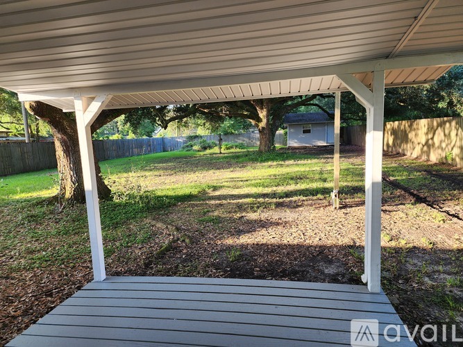 A wooden deck with a white pergola over it.