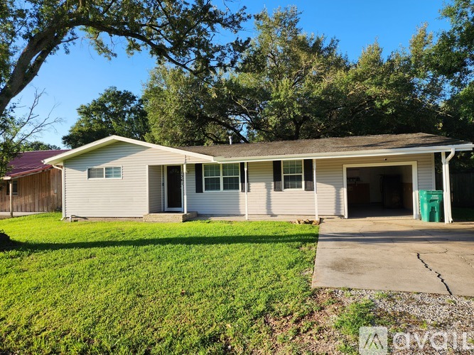 A house with a garage and a tree in front.