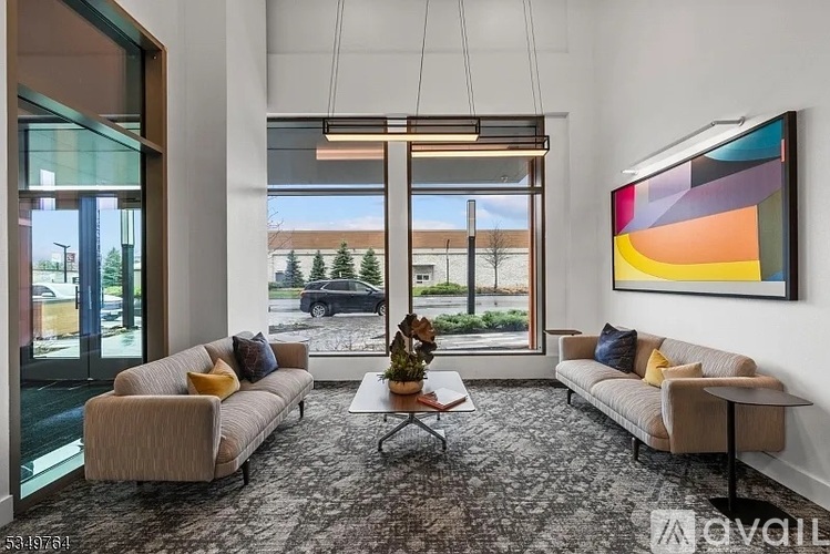 A living room with a carpeted floor, two couches, a coffee table, and a large painting on the wall.