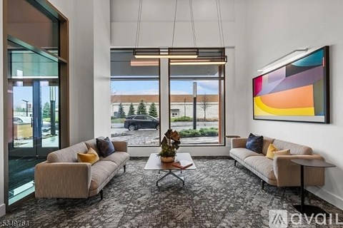 A living room with a carpeted floor, two couches, a coffee table, and a large painting on the wall.