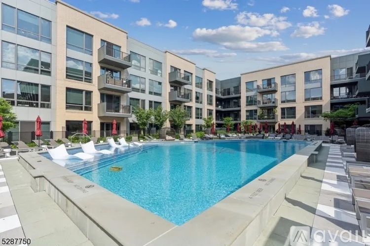 A large swimming pool is surrounded by apartment buildings.