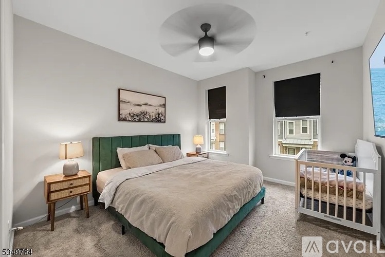 A bedroom with a large bed and a ceiling fan.