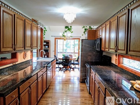A kitchen with wooden cabinets and a black countertop.