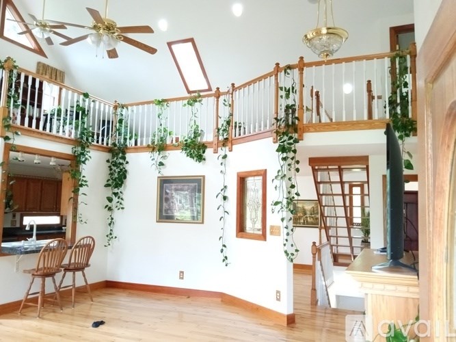 A living room with a balcony and a ceiling fan.