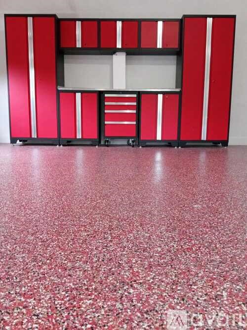 A red and white cabinet sits in a room with a red floor.