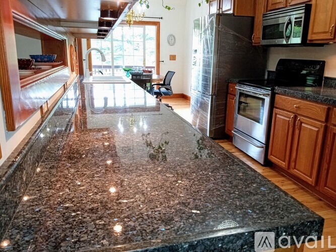 A kitchen with granite countertops and wooden cabinets.