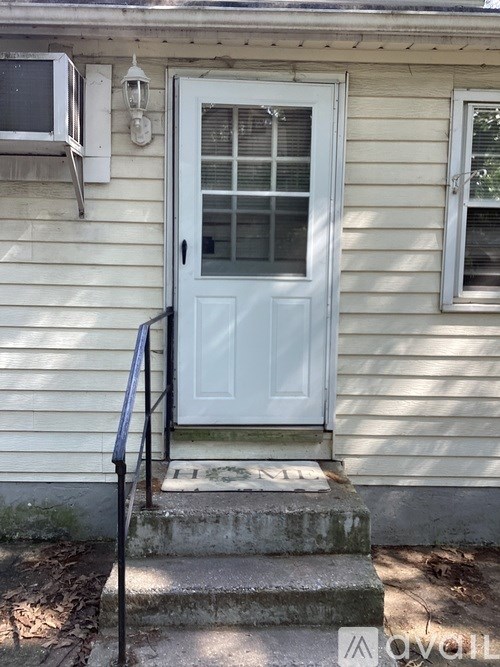 A white door with a glass window is on the front of a house.