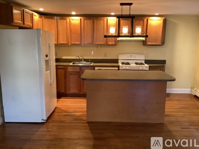 A kitchen with wooden cabinets and a white fridge.