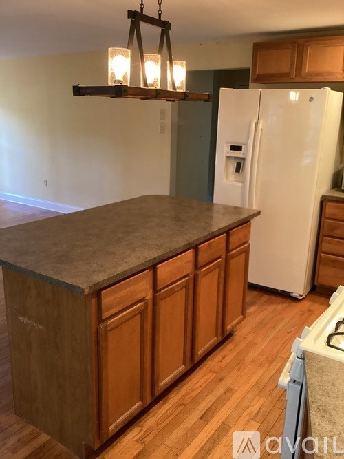 A kitchen with wooden cabinets and a white fridge.