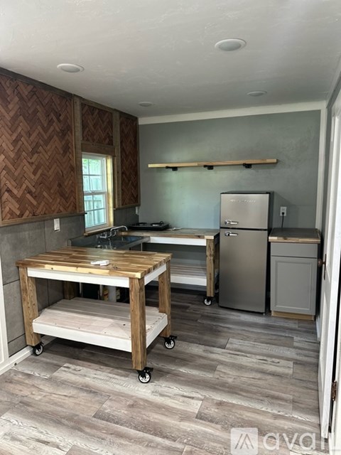 A kitchen with a wooden island and stainless steel appliances.
