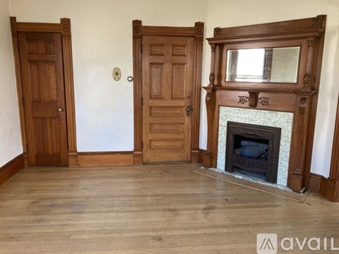 A room with a fireplace and three doors.