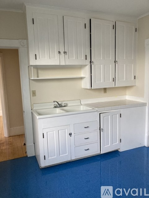 A kitchen with white cabinets and a sink.