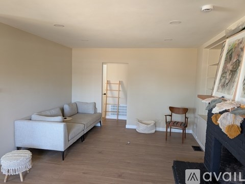 A living room with a white sofa and a wooden chair.