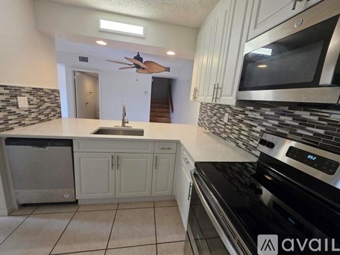 A kitchen with a black stove top oven and white cabinets.