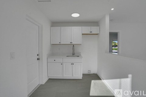A kitchen with white cabinets and a sink.