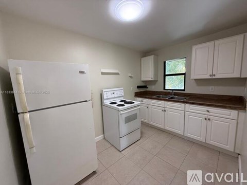 A kitchen with white appliances and cabinets.