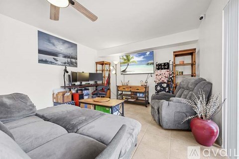 A living room with grey couches and a flat screen TV.