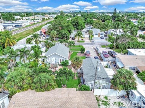 A residential area with houses and palm trees.