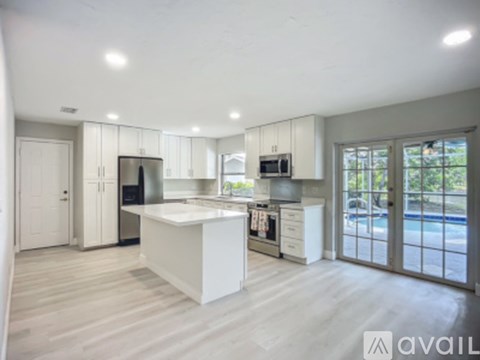 A modern kitchen with white cabinets and a large island.
