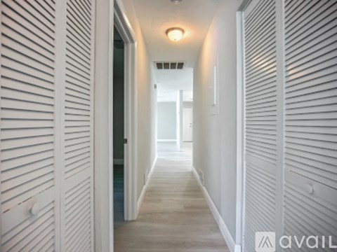 A long white hallway with a light on the ceiling.
