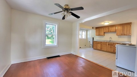 A room with a ceiling fan and wooden flooring.
